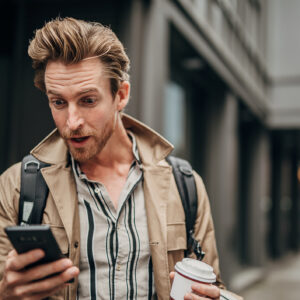 Surprised Man Using Phone On The Street In City.jpg