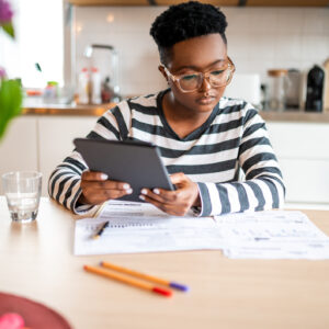 Investors considers papers on a table while holding a tablet.jpg