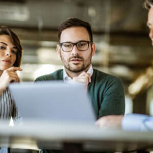 3 investors gather around a laptop.jpg